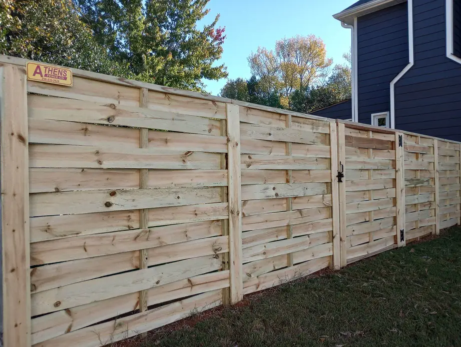 Horizontal slat wood privacy fence and matching gate installed by Athens Fence Co