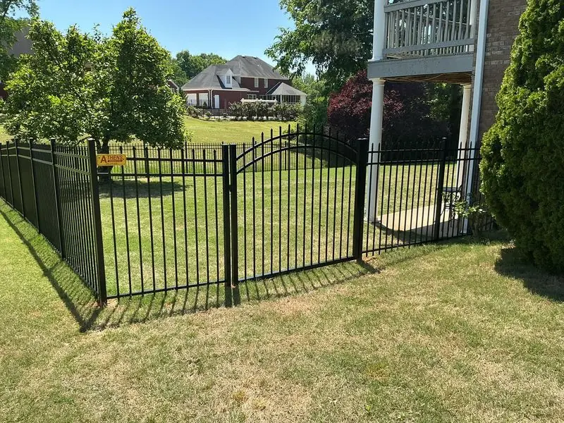 Black aluminum ornamental fence with an arched entry gate at an Athens area home